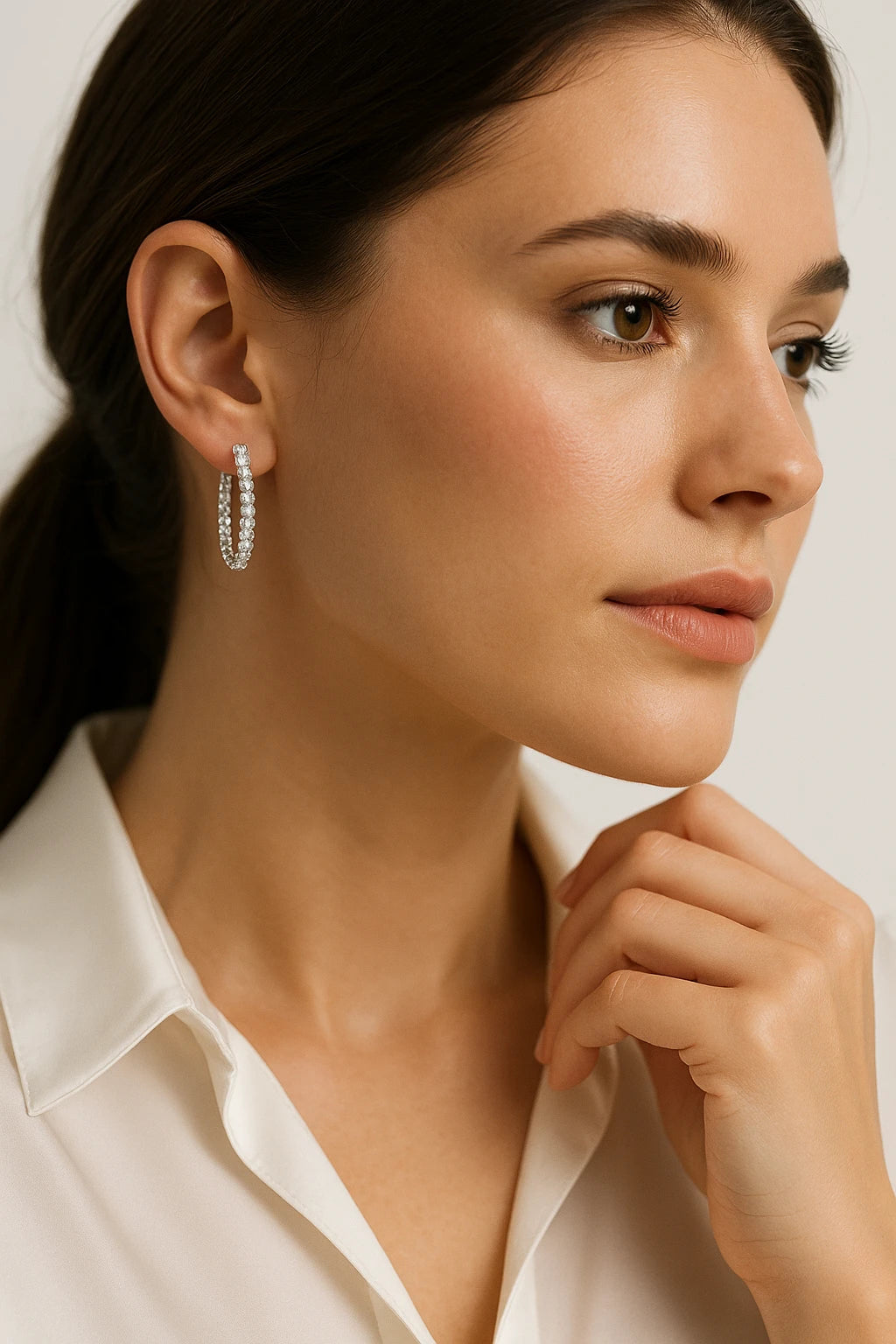 A pair of 10k white gold hoop earrings encrusted with diamonds.